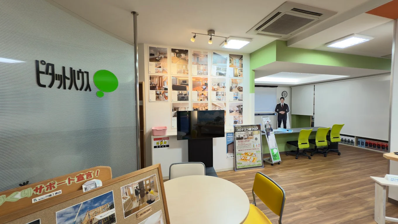 施工事例の写真が並ぶ明るい店内の打合せスペース